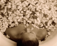 Woman in bathtub with flower petals, high angle - Jack Hollingsworth