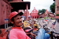 Malaysia, Malacca, pedicab driver infront of the Stadhuys. - Steve Raymer