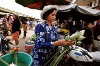 Cambodia, Phnom Penh, Cambodian woman buys flowers in market. - Steve Raymer