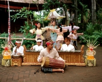 Indonesia, Bali, man playing hand drum, boys playing instruments and girls dancing in background in traditional costume - Jack Hollingsworth