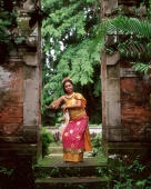 Indonesia, Bali, Balinese dancer in doorway, trees in background - Jack Hollingsworth