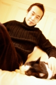 Man sitting and petting cat. - Leila  Pivetta