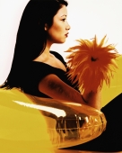 Young woman sitting on yellow inflatable chair, profile. - Erik Soh