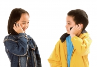 Two children (boy and girl) talking on cellular phones, white background. - Jade Lee