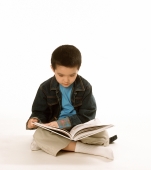 Young boy reading book, white background. - Jade Lee