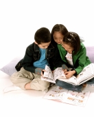 Three young children (two girls, one boy) reading books, white background. - Jade Lee