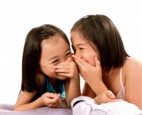 Two young girls laughing, white background. - Jade Lee