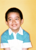 Young boy smiling, yellow background. - Jade Lee