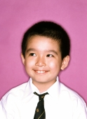 Young boy dressed in tie and shirt, smiling, purple background. - Jade Lee