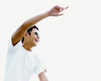 Young man wearing sunglasses, pointing, smiling, white background - Eric Ceret
