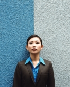 Executive woman standing against split colored background, portrait. - Jack Hollingsworth