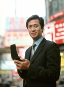 Executive man using PDA in street, portrait. - Jack Hollingsworth