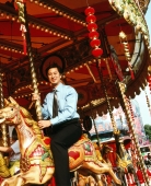 Male executive sitting on carousel. - Jack Hollingsworth
