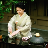 Japan, Woman in kimono performing outdoor tea ceremony - Rex Butcher