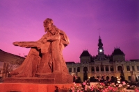 Vietnam, Saigon, Statue of Ho Chi-Minh with Hotel De Ville in background at dusk - Gareth Jones