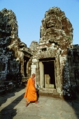 Cambodia, Angkor Thom, monk walking between face towers of the Bayon - Gareth Jones
