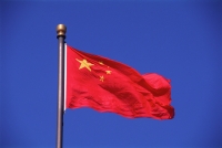 China, Beijing, National flag against blue sky - Gareth Jones