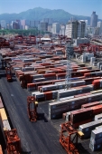 China, Hong Kong, Containers at port, buildings in background - Gareth Jones