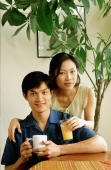 Couple with drinks at home, portrait - Jade Lee