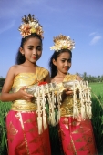 Indonesia, Bali, Young Balinese dancers in costume with offerings in rice paddy. - Jill Gocher