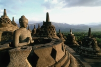 Indonesia, Java, Buddha figure at Borobudur temple,  mountains in background - Jill Gocher