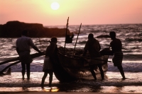 Sri Lanka, Fishermen launching boat at dawn, silhouette - Jill Gocher