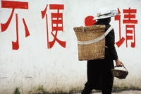 China, Lijiang, Naxi person carrying basket - Jill Gocher