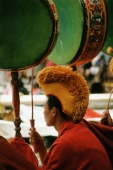 China, Szechuan (Sichuan), Kham region, Monk playing drums at Temple Puja. - Jill Gocher