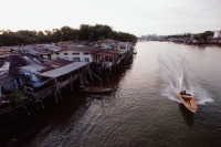 Brunei Darussalam, Borneo, A boat speeds along the river. - Steve Raymer