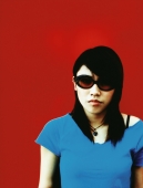 Young woman in sunglasses, red background. - Jack Hollingsworth