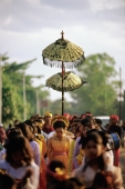 Indonesia, Lombok, a bride walking under a canopy and accompanied by female attendants, following musicians to the groom's home. - Steve Raymer