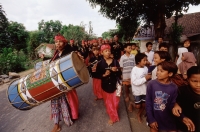Indonesia, Lombok, Drummers leading a wedding procession past a crowd on the street. - Steve Raymer