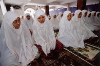 Indonesia, Jakarta, Young students at the Asshiddiqiyah Muslim School kneeling for prayers. - Steve Raymer