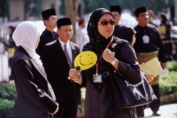 Brunei Darussalam, Borneo, A Muslim woman fanning herself to keep cool. - Steve Raymer