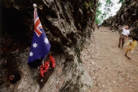 Thailand, Kanchanaburi, Hellfire Pass, An Australian flag sits on top of a plaque on the trail down to Hellfire Pass. - Steve Raymer