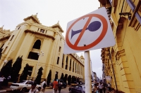 Myanmar (Burma), Yangon (Rangoon), A No Horns sign near the side of the road, colonial buildings in background. - Steve Raymer