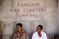 Myanmar (Burma), Yangon (Rangoon), Men sitting by one of the signs in Rangoon War Cemetery. - Steve Raymer