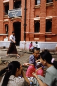 Myanmar (Burma), Yangon (Rangoon), Groups of people having tea and snacks outside a colonial brick building. - Steve Raymer