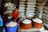 Myanmar (Burma), Yangon (Rangoon), A Burmese woman selling rice of varying grades of quality in a market in Yangon. - Steve Raymer