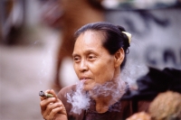 Myanmar (Burma), Yangon (Rangoon), A Burmese woman smoking a homegrown, hand-rolled cigarette called a "cheroot". - Steve Raymer