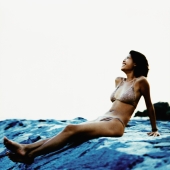 Young woman in bikini sitting on breakwater - Erik Soh