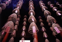 Malaysia, Kuala Lumpur, Chinatown, Burning incense coils hanging from ceiling. - Steve Raymer