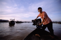 Vietnam, Long Xuyen, Woman driving boat in floating markets on Mekong River. - Steve Raymer
