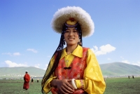 China, Szechuan (Sichuan), Kham region, Khampa woman wearing traditional hat, goatskin and brocade at Nomad festival. - Jill Gocher