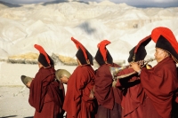Nepal, Mustang, Buddhist lamas play their instruments in a procession to toss out evil spirits. - Jill Gocher