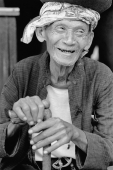 Indonesia, Java, Blitar, Elderly man holding walking stick, smiling. - Mary Grace Long