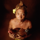 Indonesia, Bali, Ubud, Balinese man holding fighting cock, view from above. - Martin Westlake