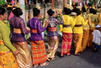 Indonesia, Bali, Candi Dasa, Women in ceremonial dress arrive at temple ceremony. (grainy) - Martin Westlake