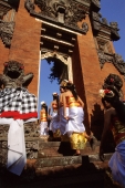 Indonesia, Bali, Gianyar, Cremation ceremony, girls from ceremonial procession enter temple. (grainy) - Martin Westlake