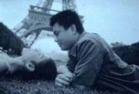Young couple lying on grass, Eiffel Tower in background. - Leila  Pivetta